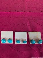 Front view of three pairs turquoise stud earrings on display cards