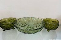 Overview of three green glass bowls