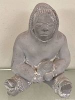 Front view of Inuit fisherman figurine holding fish
