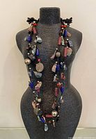 Full view of long handcrafted necklace draped on bust form