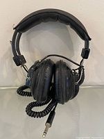 Front view of headphones showing earcups, headband and coiled cable