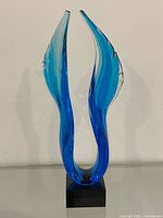 Front view of blue glass angel wings sculpture on black base