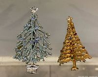 Front view of both Christmas tree brooches