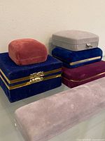 Six velvet jewelry boxes grouped on glass surface