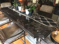 Top view of the polished black marble dining table with gold veining and custom edge detail.
