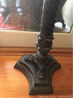 Close-up of lower base showing ornate tripod base and claw feet