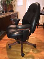 Angled left-front view showing padded seat, contoured backrest and wood-finish base.