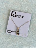 Front view of pendant on original card showing design and brand