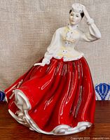 Front view of Royal Doulton Gail figurine showing blouse, bows and red skirt