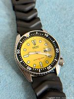 Front angled close-up of watch showing dial, bezel, crown and strap end