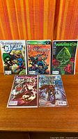 Five bagged comics laid out: Brightest Day The Atom Special #1, Flashpoint Frankenstein & the Creatures of the Unknown #1, The New 52 Futures End #2, another Futures End issue, Green Arrow issue