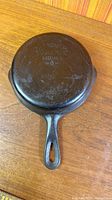 Full underside view of skillet with handle showing maker’s mark and overall wear