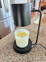 Front view of candle warmer with jar candle beneath heating hood