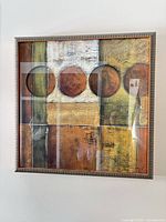 Front view of framed abstract artwork showing design, colors, frame and signature