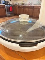 Grill with glass lid on white base