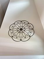Wall-mounted round metal mandala decor viewed from below
