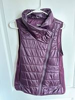 Front view of purple Reebok puffer vest showing asymmetrical zipper and collar