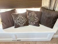All four brown pillows displayed on window seat