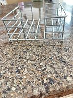 Front side view of stainless steel wire napkin stand showing overall form and construction