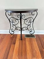 front view of demilune console table showing wood top and scrolled iron base