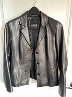 Front view of black leather blazer on hanger