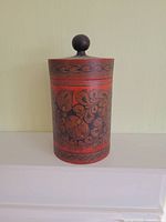 Front view of cylindrical hand-painted Russian wooden canister with lid and knob