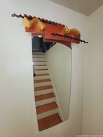 Front view of tall wall mirror with sculptural teak, gilded maple and ebonized maple top surround