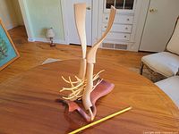 Full view of sculptural headdress on tabletop with measuring stick for scale