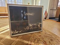 framed sumi ink painting leaning against sofa showing artwork, frame and glazing