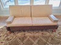 Front view of entire sofa showing leather upholstery, wenge base, maple feet, cushions and arm bolsters