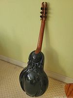 Rear view showing sculpted black fiberglass body, teak neck, carved headstock