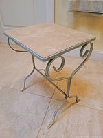 overall view of wrought iron side table showing travertine top and scroll legs
