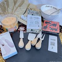 Group shot showing napkins, candle, bowl with spoon, coasters, cheese board, knives, spreaders and oil sprayer