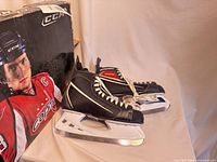 Pair of CCM skates beside original box