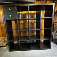 Front view of black 4x4 cube bookcase showing cubbies and two drawers