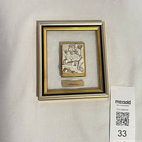 Front view of framed silver relief artwork