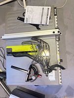 Top view showing table surface, rip fence, blade guard, miter gauge, wrenches and manual