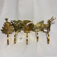 All five brass stocking hooks lined up front view