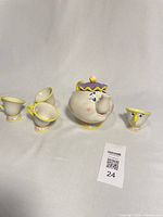 Full view of Mrs. Potts teapot with lid and four Chip cups