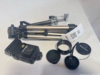 Folded Hi-Pro tripod, Blacks CB64 flash, two lens caps, extension ring visible