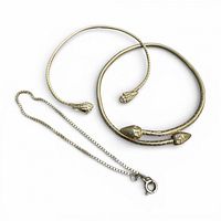 Two snake-head bangles and box chain bracelet laid out