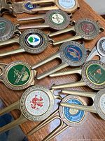Group of metal divot tools with various course logos
