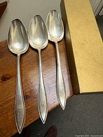 Three Birks sterling silver serving spoons on table, full view