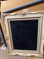 Front view of ornate cream ivory frame with black velvet insert