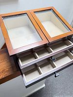 Top view showing glass lids and open drawers with compartmented interiors