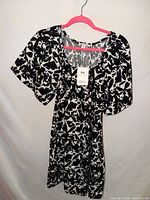 Full view of black and white patterned dress on hanger showing length and pattern