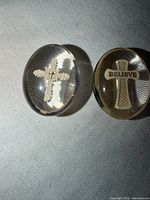 Two clear acrylic oval stones side by side showing embedded crosses