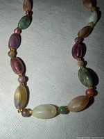 close-up of mixed oval stone beads with gold spacers