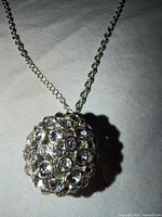 Close-up of crystal-covered ball pendant on chain