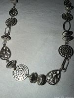 Close-up of lower section with openwork circle, teardrop, and fluted beads